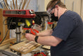 Load image into Gallery viewer, Artist Cory B. in the middle of making a wooden cutting board
